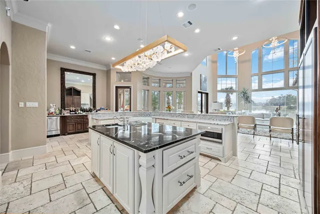 a kitchen with granite countertop a sink stove and cabinets