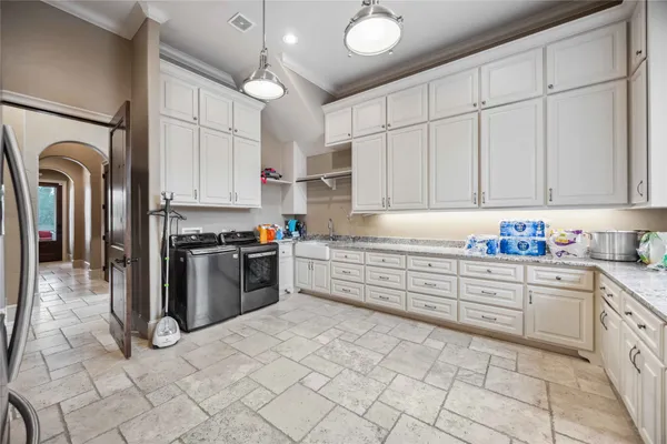 a kitchen with stainless steel appliances granite countertop a refrigerator a stove and a sink
