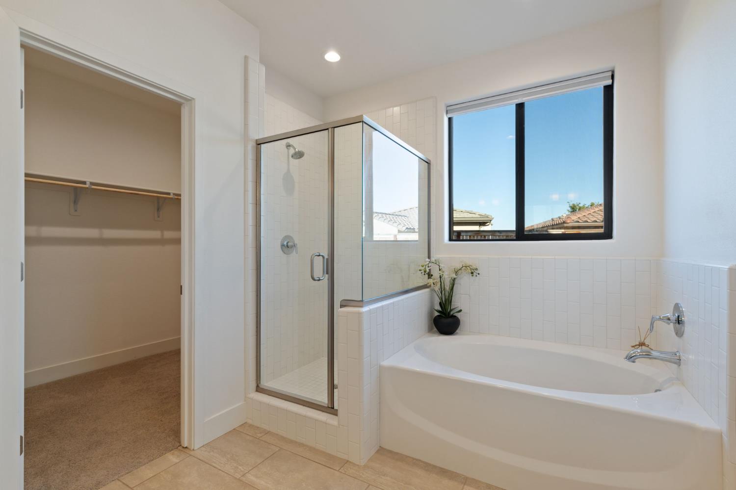 1022 Moonrise Way Madera, CA 93636 - Photo 21 of 52 a bathroom with a tub a mirror and a shower