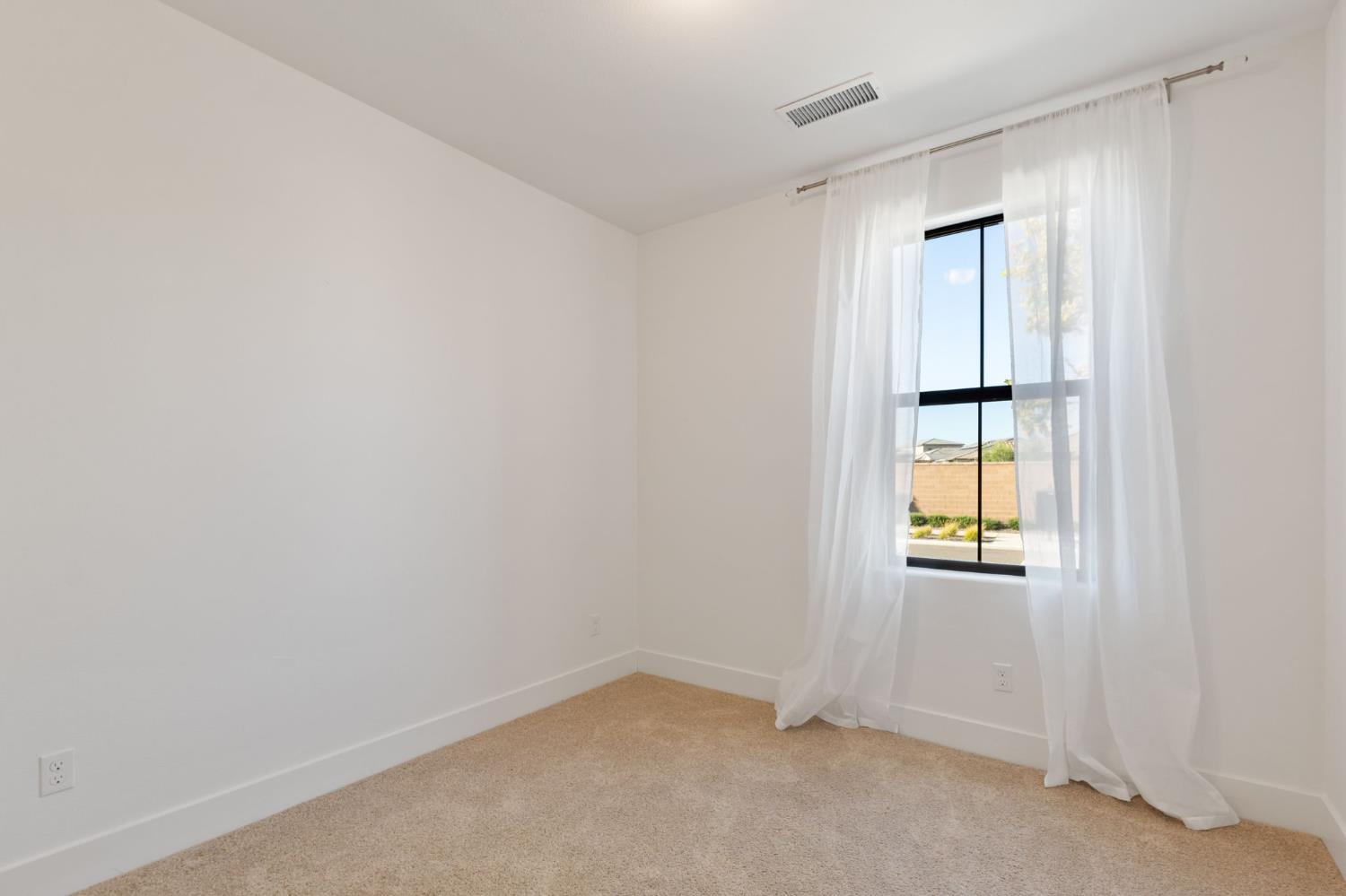 1022 Moonrise Way Madera, CA 93636 - Photo 25 of 52 an empty room with a window and wooden floor