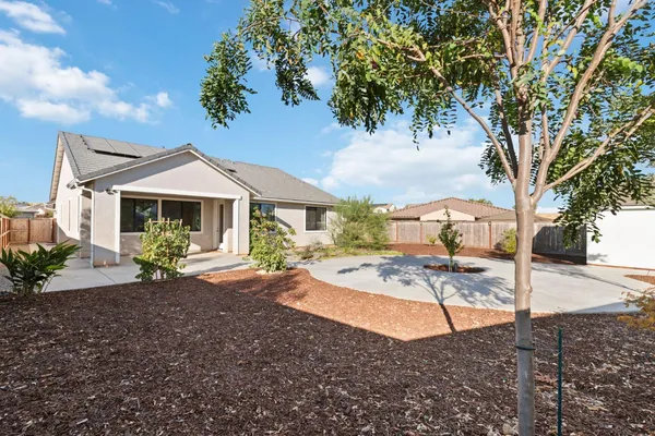 a view of a house with backyard and trees