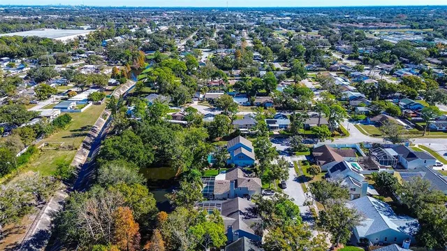 an aerial view of residential houses with outdoor space and trees