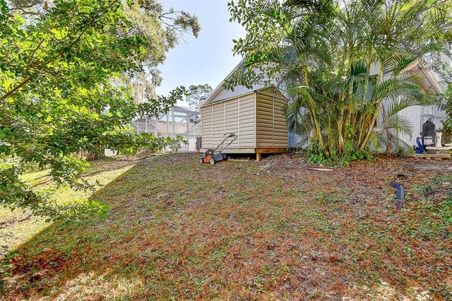 a backyard of a house with large trees and plants