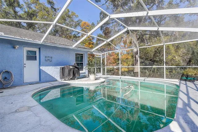 a view of a swimming pool with a patio and a yard