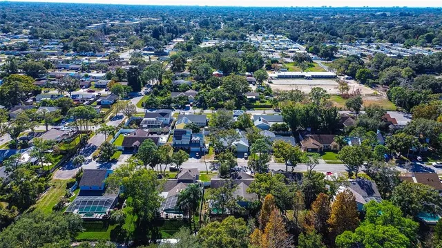 an aerial view of residential houses with city and green space