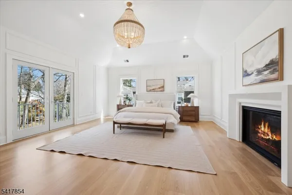 a spacious bedroom with a bed and a chandelier