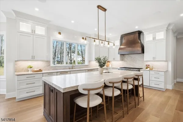 a kitchen with kitchen island granite countertop a sink counter and chairs