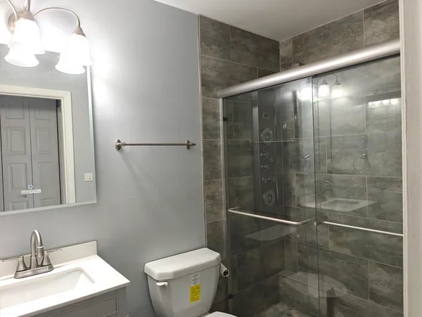 a bathroom with a shower a toilet and a sink