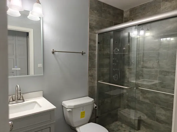 a bathroom with a shower a toilet and sink