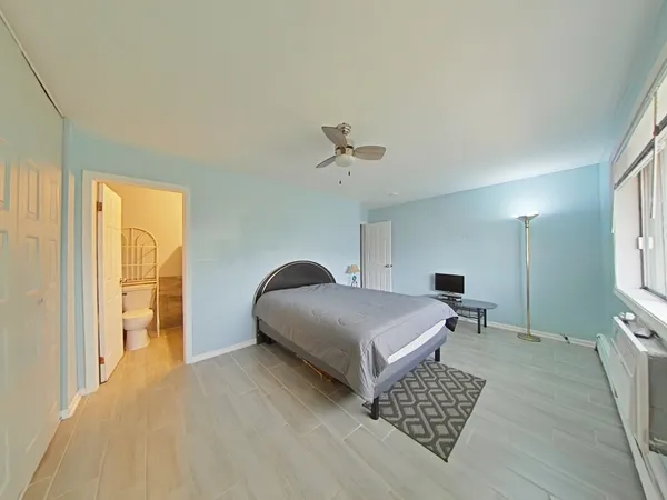 a spacious bedroom with a bed and a chandelier