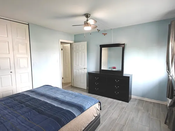 a bedroom with a bed and a mirror on dresser