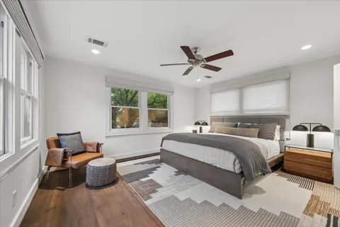 a spacious bedroom with a bed a couch and a window
