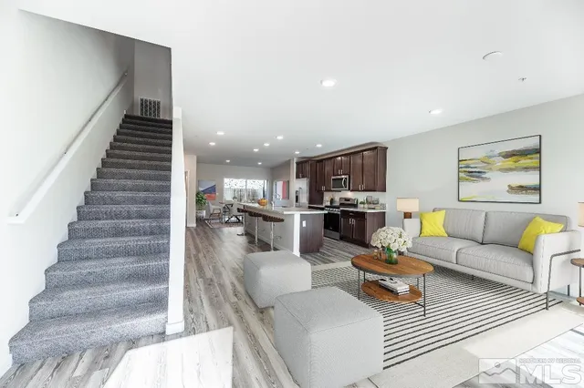 a living room with furniture and a view of kitchen