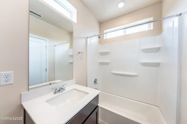 a bathroom with a sink shower and a mirror
