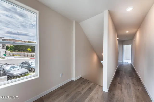 a view of a hallway with wooden floor and a window