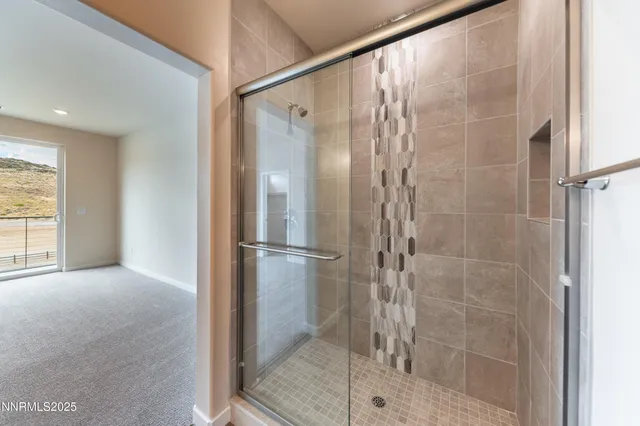 a bathroom with a shower and a glass door