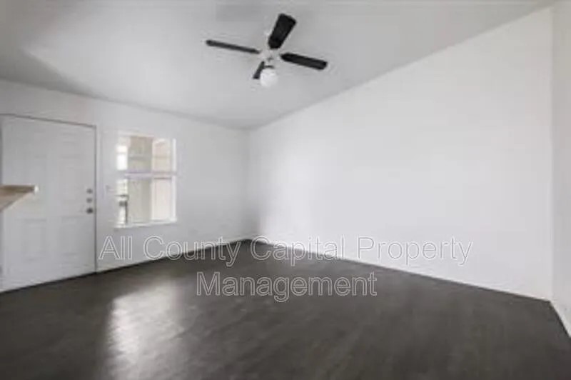 8503 Colony Loop Drive Austin, TX 78724 - Photo 4 of 4 an empty room with wooden floor cabinet and windows