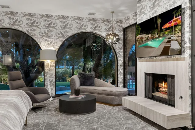 a view of a swimming pool with a lounge chairs and palm tree