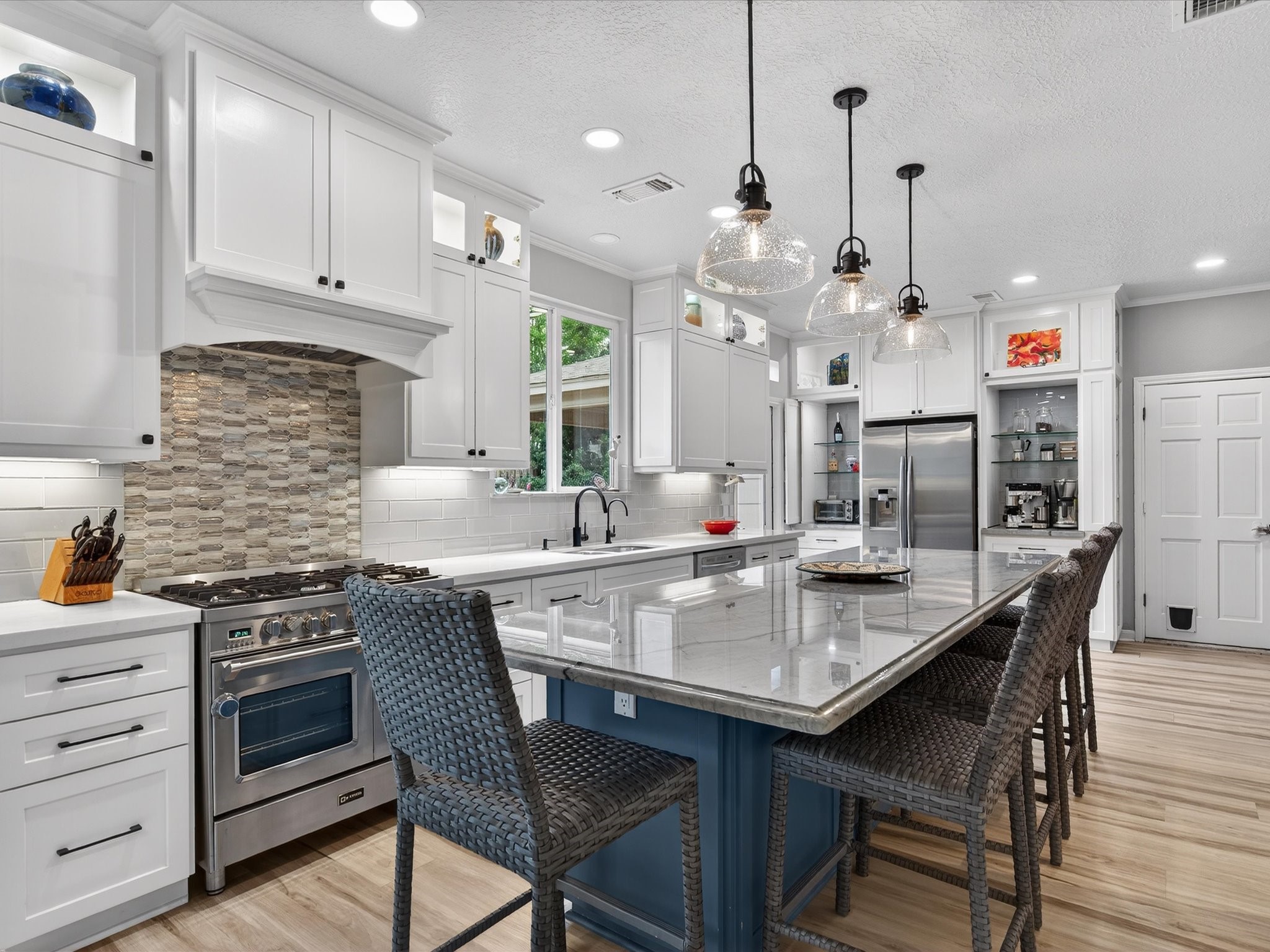 6207 Sandypine Drive Spring, TX 77379 - Photo 12 of 46 Completely remodeled in 2020, this stunning kitchen showcases an oversized island, quartz countertops, custom cabinetry, and a designer backsplash that instantly catches the eye.