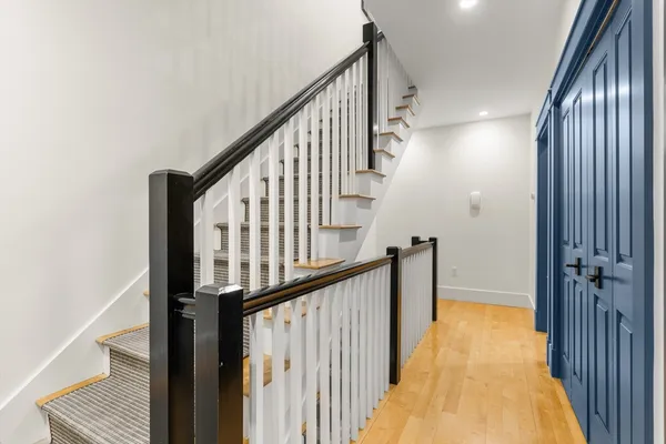 a view of staircase with railing and a rug