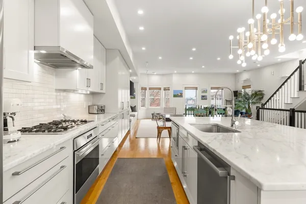 a large kitchen with stainless steel appliances granite countertop a lot of counter space