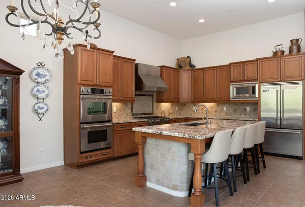 a kitchen with stainless steel appliances granite countertop a stove refrigerator sink and microwave