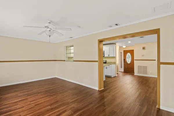 a view of a big room with wooden floor and a kitchen