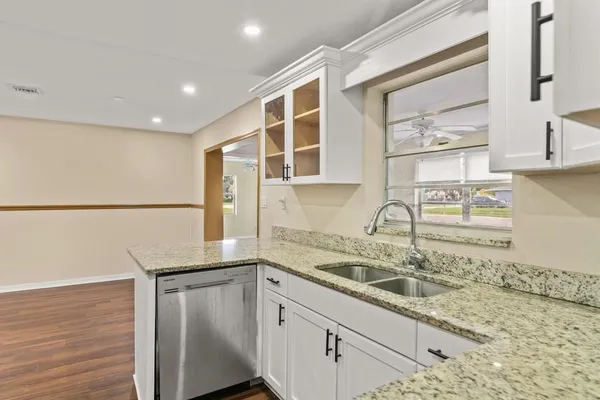 a kitchen with a sink cabinets and wooden floor