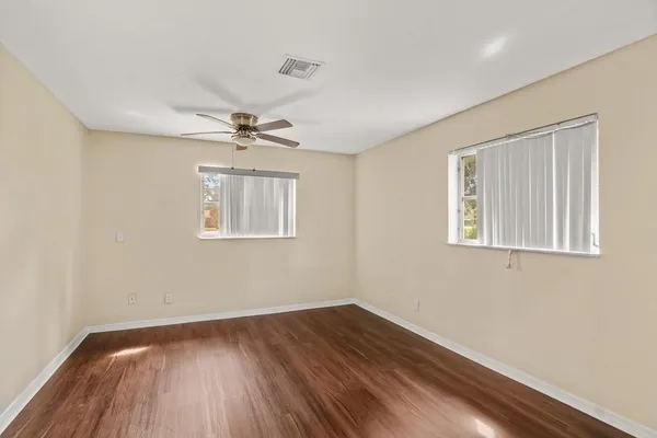 a view of a room with wooden floor and a ceiling fan