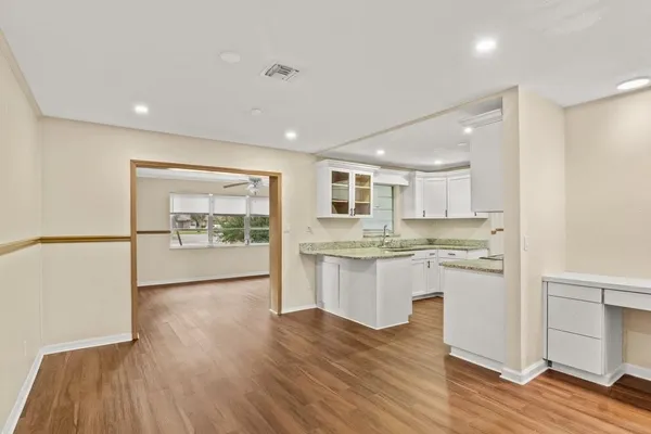 a view of a kitchen cabinets a sink and wooden floor