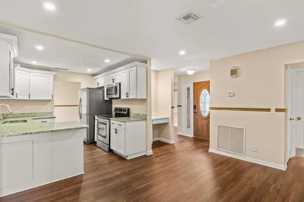 a kitchen with white cabinets and stainless steel appliances