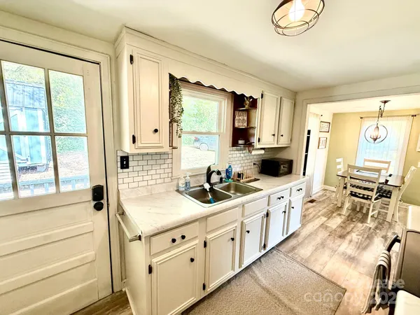 a kitchen with stainless steel appliances sink cabinets and window