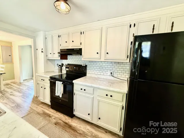 a kitchen with stainless steel appliances white cabinets and a refrigerator