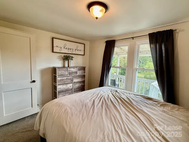 a bedroom with a bed and a large window