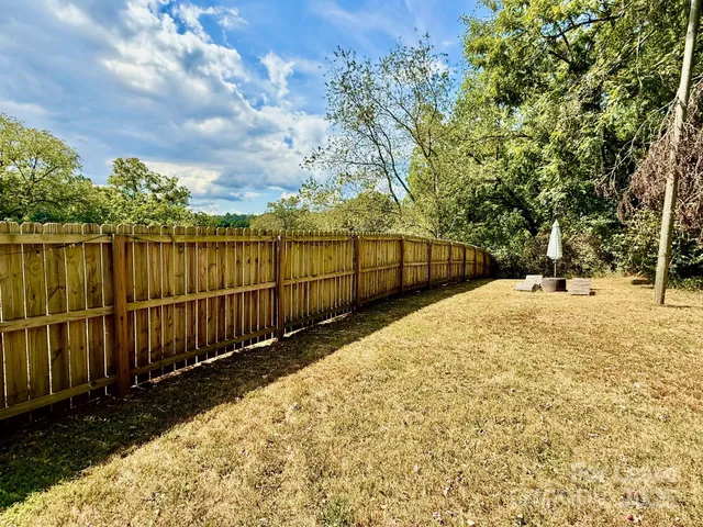 a view of backyard space with wooden fence