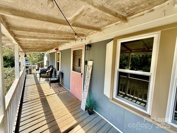a view of a hallway with wooden floor and furniture
