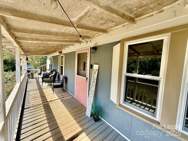 a view of a hallway with wooden floor and furniture