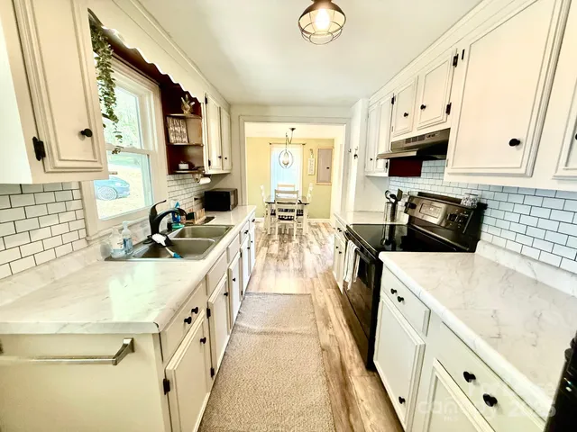 a kitchen with stainless steel appliances granite countertop a sink stove and cabinets