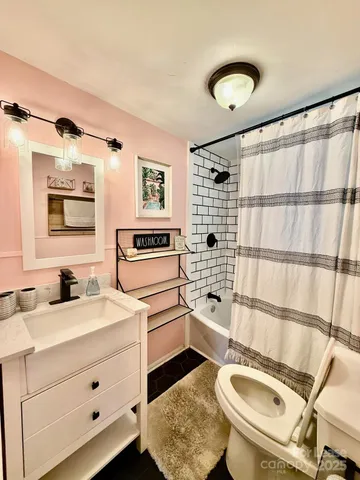 a bathroom with a sink toilet double vanity and tub
