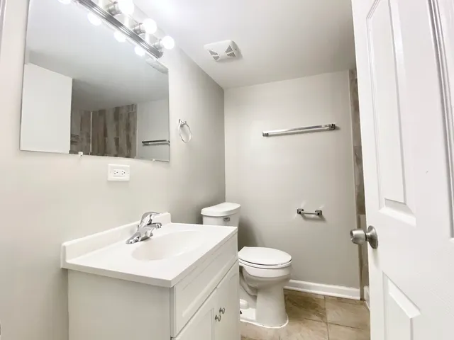 a bathroom with a sink mirror and toilet