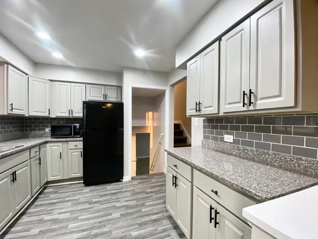 a kitchen with stainless steel appliances granite countertop a refrigerator and cabinets