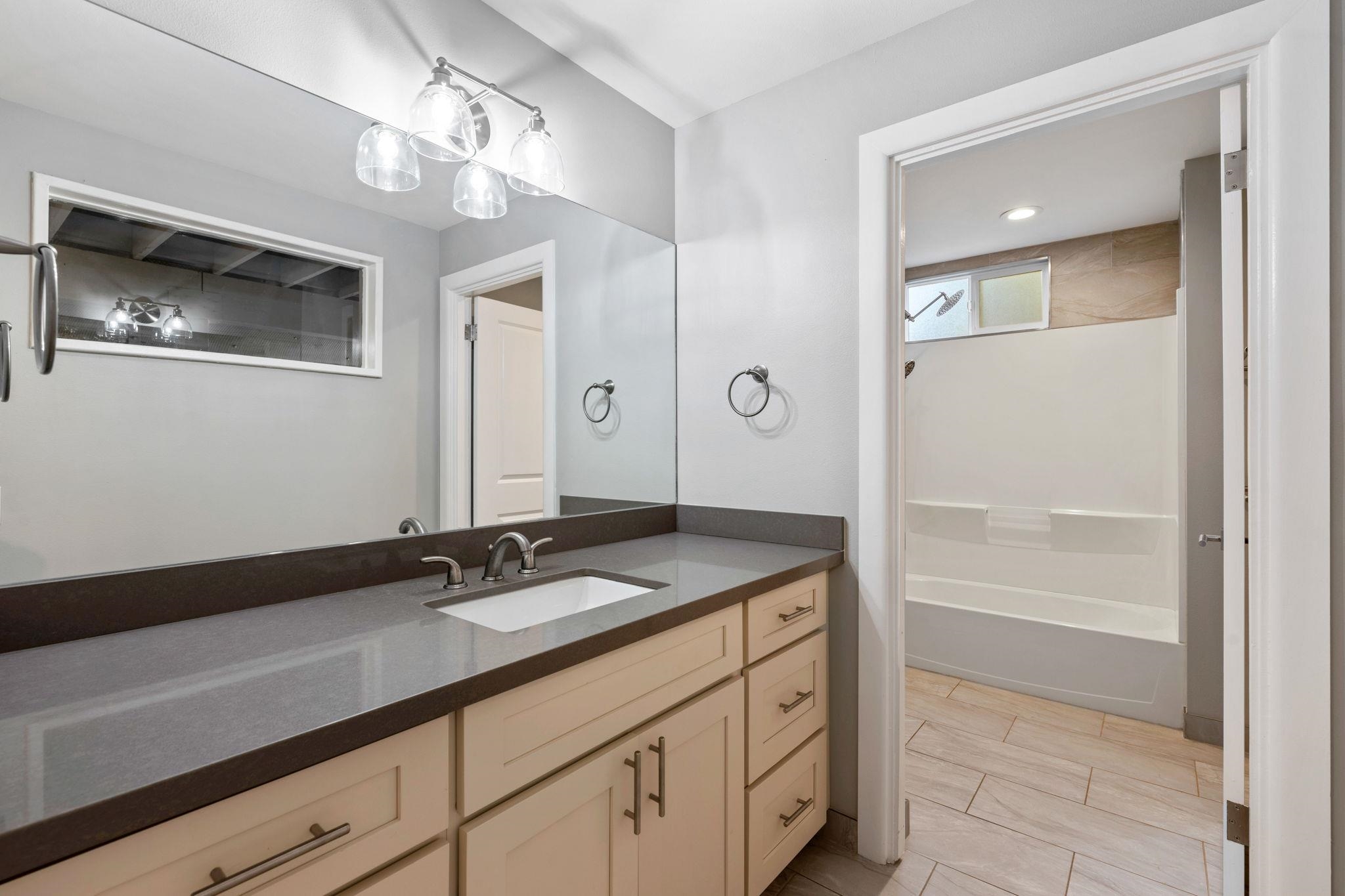 3124 Nahenahe Place Kihei, HI 96753 - Photo 32 of 50 a bathroom with a granite countertop sink a light fixture and a mirror