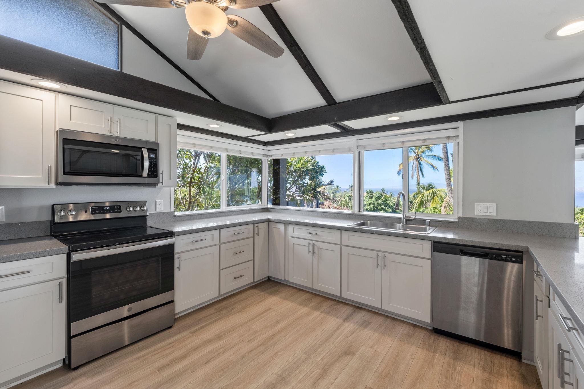 3124 Nahenahe Place Kihei, HI 96753 - Photo 9 of 50 a kitchen with stainless steel appliances granite countertop a stove and a wooden floors
