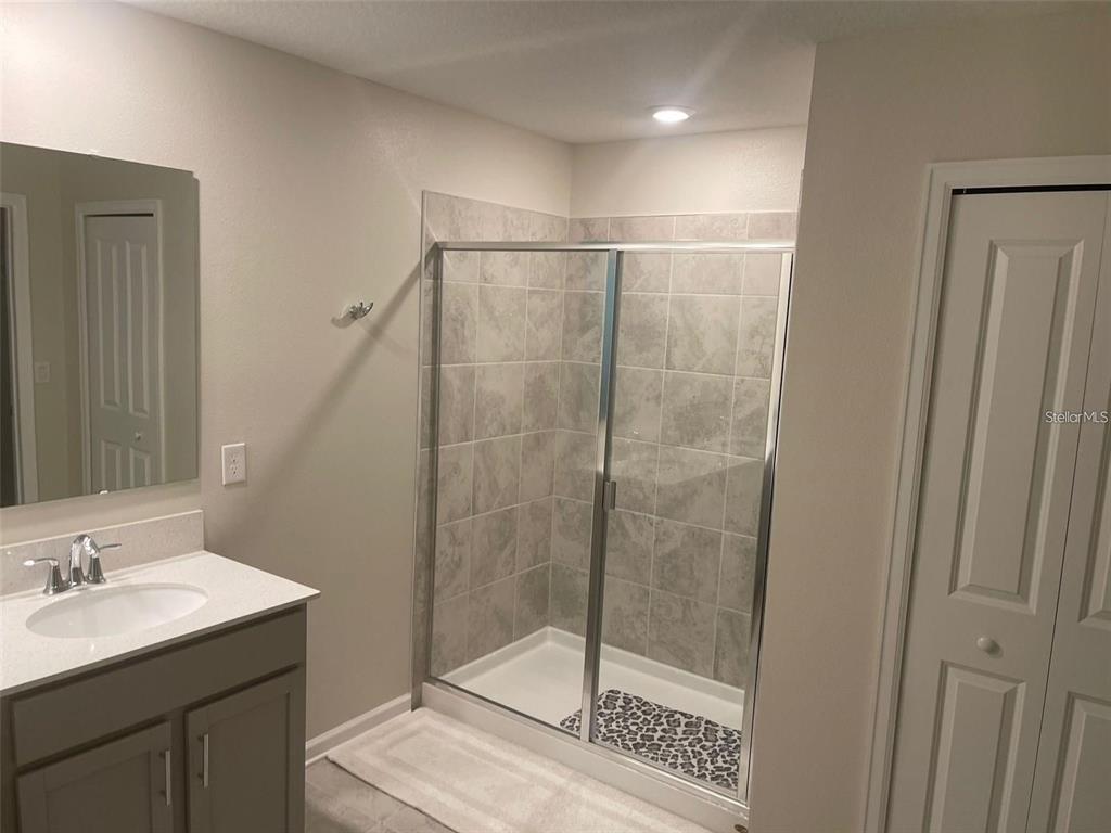 4491 Magnolia Ridge Court Kissimmee, FL 34746 - Photo 8 of 21 a bathroom with a shower sink and mirror