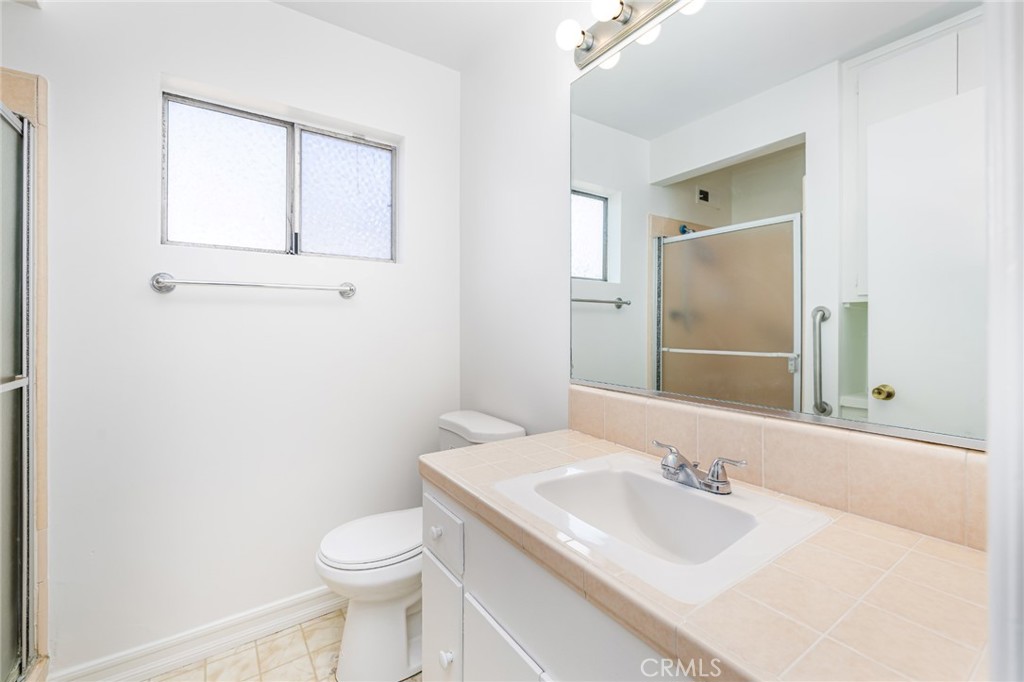 15838 Eccles Street North Hills, CA 91343 - Photo 27 of 38 a bathroom with a granite countertop sink toilet and mirror