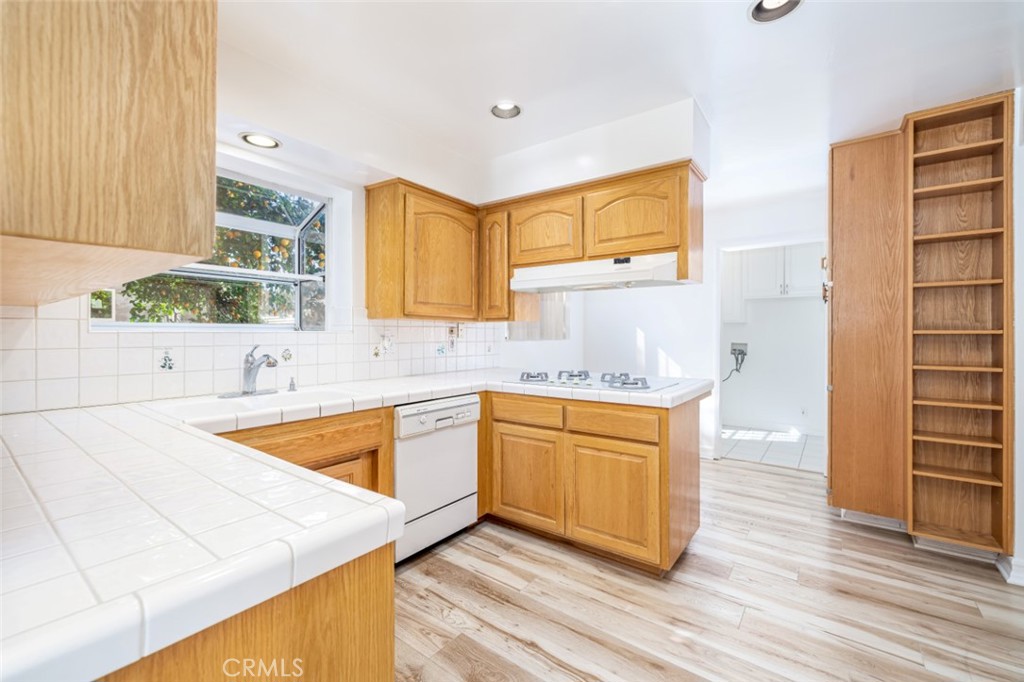 15838 Eccles Street North Hills, CA 91343 - Photo 9 of 38 a kitchen with stainless steel appliances granite countertop a sink a stove cabinets and wooden floor