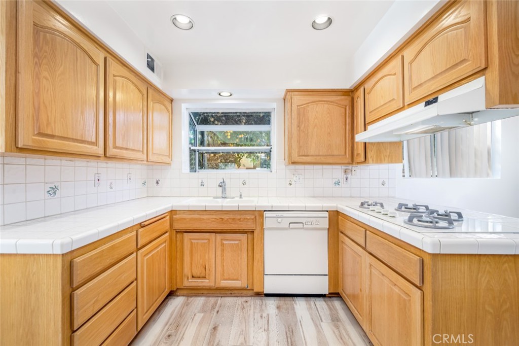 15838 Eccles Street North Hills, CA 91343 - Photo 10 of 38 a kitchen with stainless steel appliances granite countertop a sink stove cabinets and wooden floor