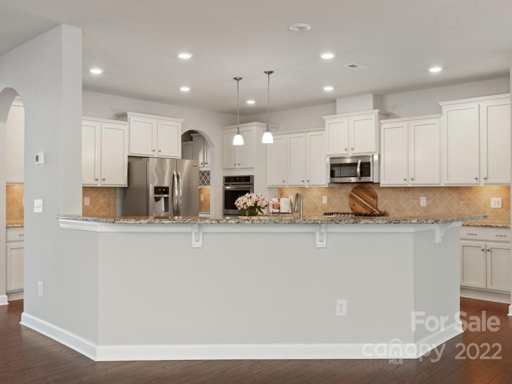 1335 Bryson Gap Drive Fort Mill, SC 29715 - Photo 15 of 29 a large kitchen with stainless steel appliances granite countertop a stove a sink a refrigerator and white cabinets