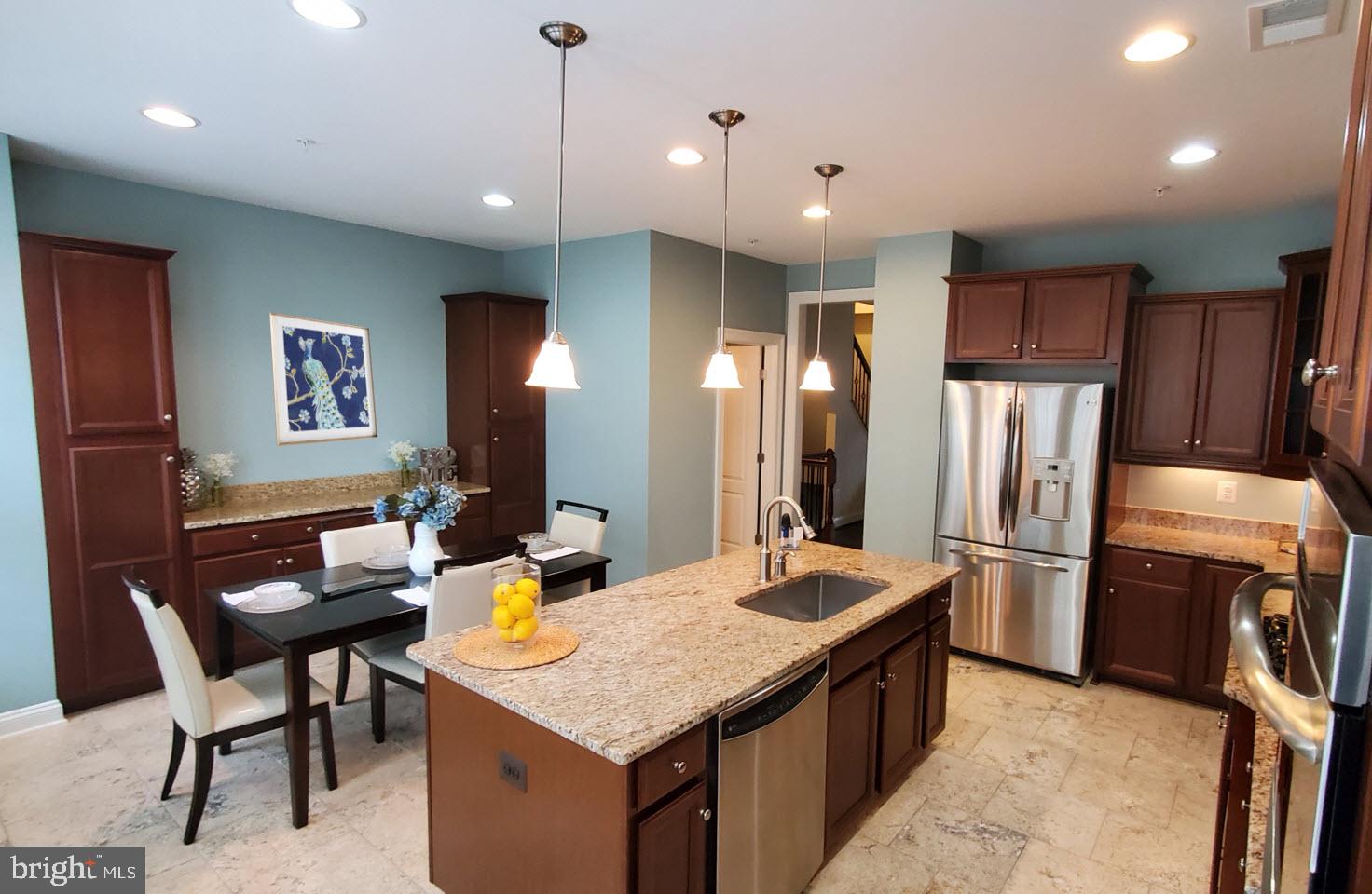 503 Rampart Way, Unit 16 Oxon Hill, MD 20745 - Photo 7 of 35 a kitchen with stainless steel appliances granite countertop a kitchen island a stove and a refrigerator