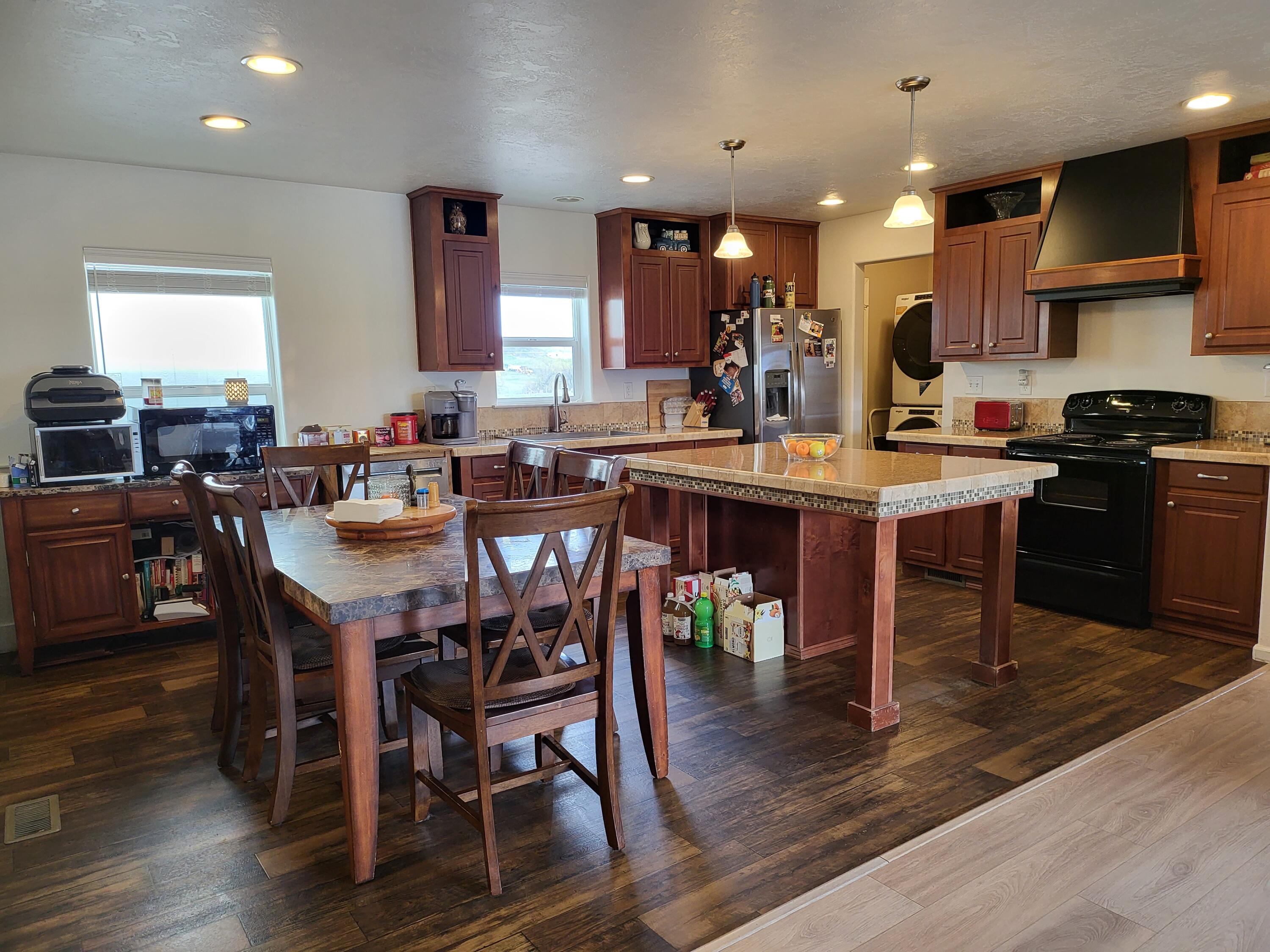 2540 East Gregory Road Central Point, OR 97502 - Photo 6 of 19 a kitchen with stainless steel appliances granite countertop a table chairs sink and cabinets